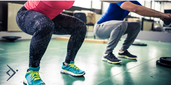 A woman and man squatting. Doing great exercise for immunity!